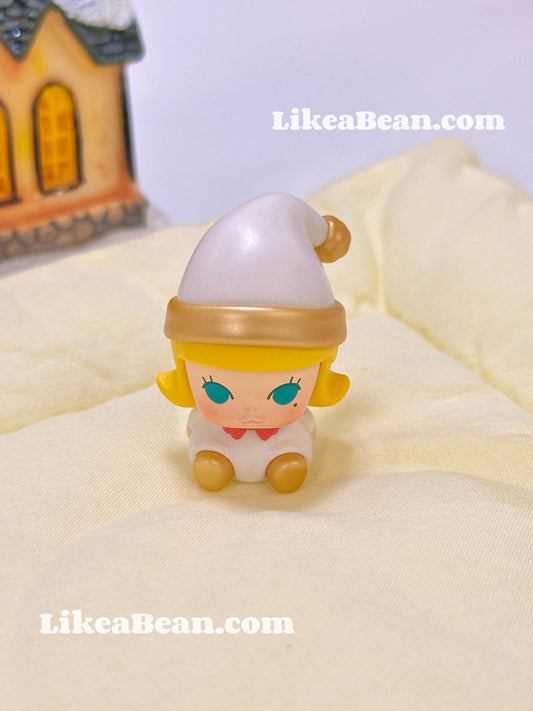 Small figurine with blonde hair and blue eyes on a yellow surface, with 'LikeaBean.com' branding.